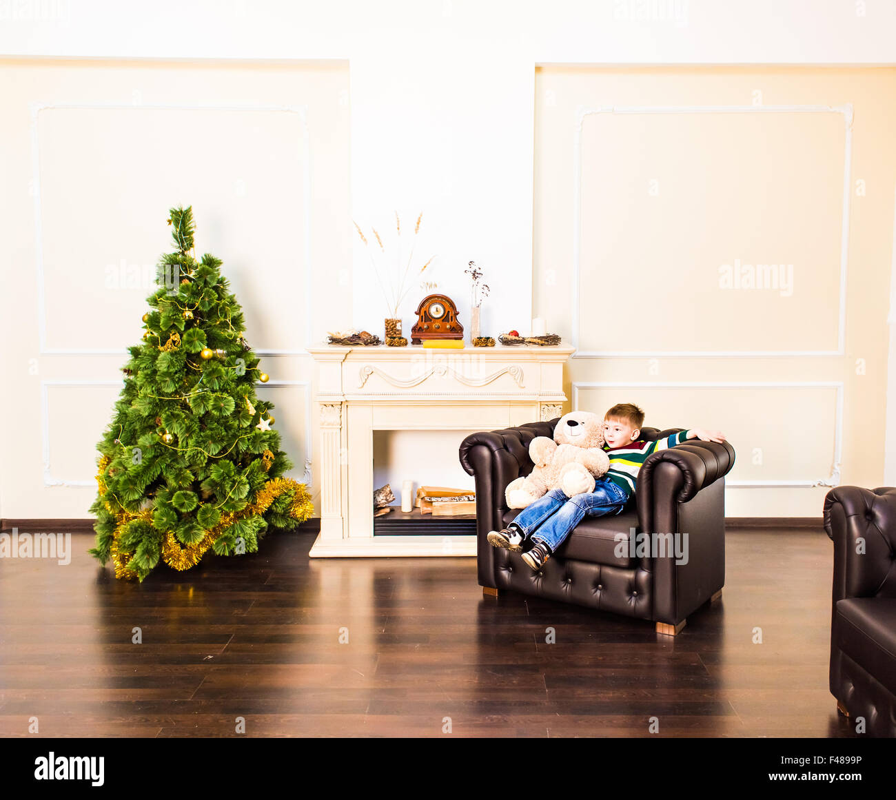 young boy holding teddy bear near the New Year tree Stock Photo - Alamy