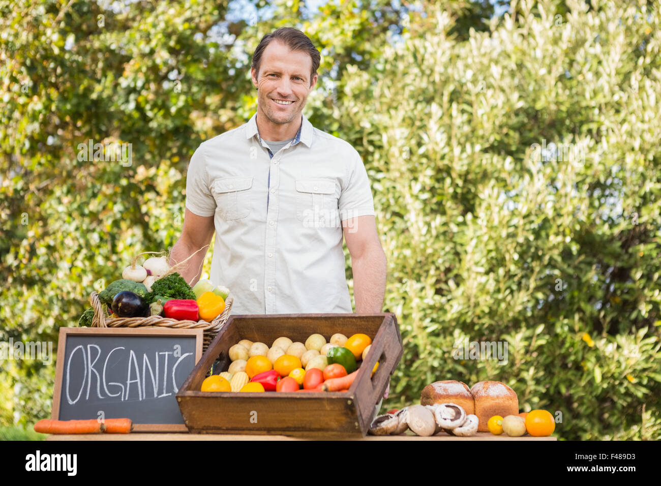 Smiling farmer holding a basket of vegetables Stock Photo - Alamy