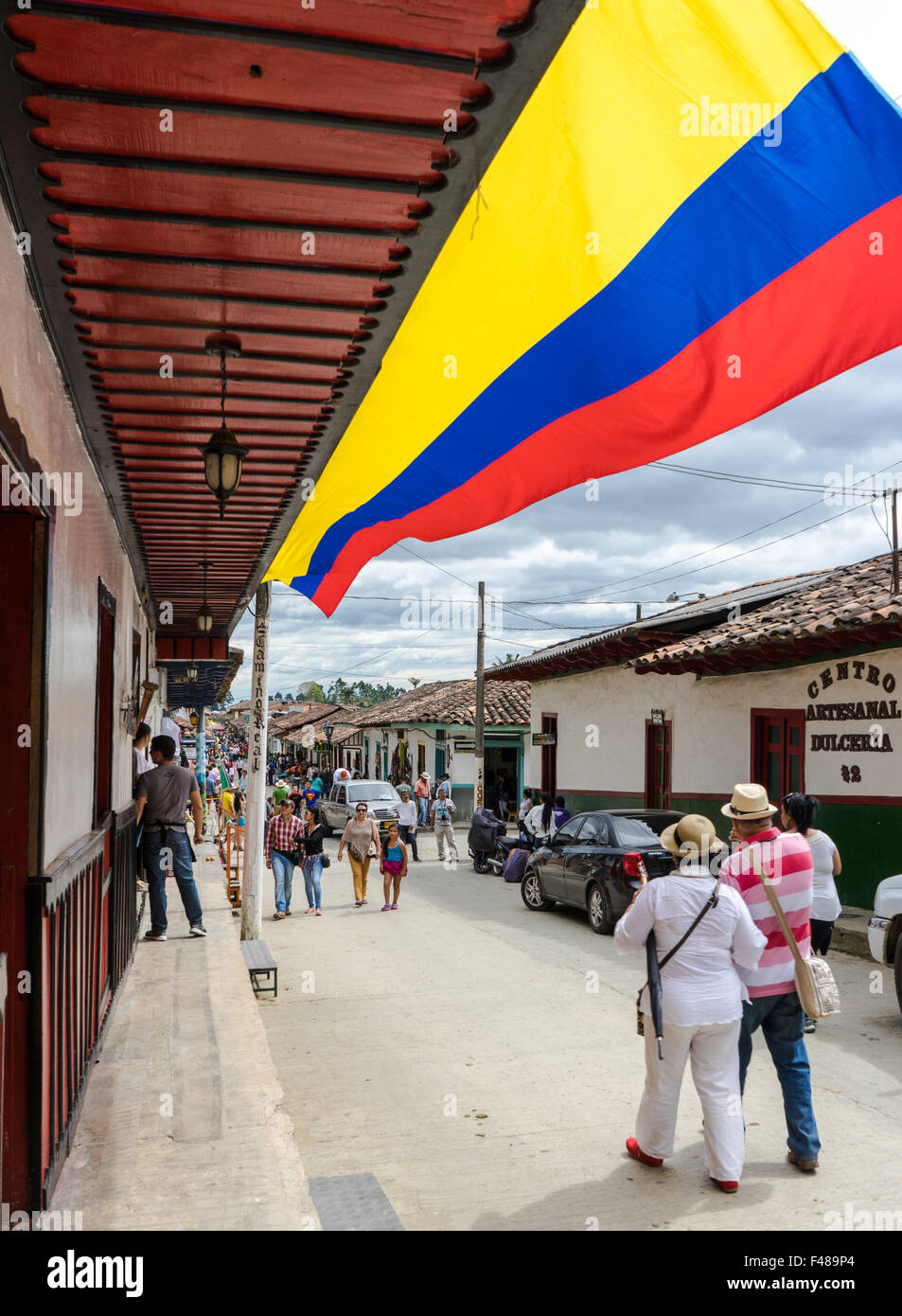A Colombian flag waves through a cloudy day on Carrera 6 in Salento. June, 2015. Quindio, Colombia Stock Photo