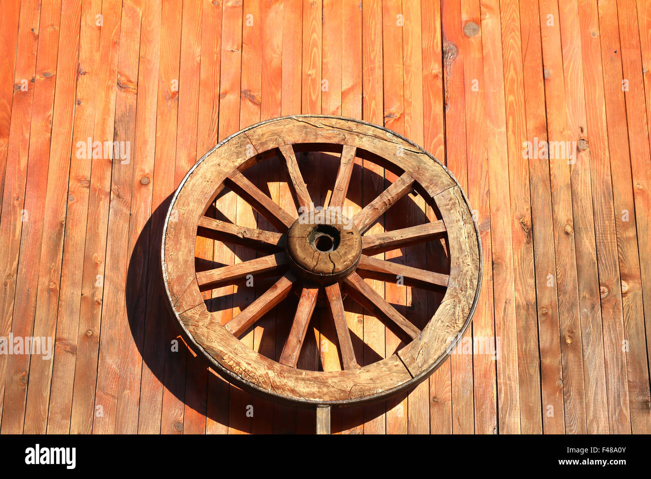 Wooden wheel hanging on the wall photographed close up Stock Photo