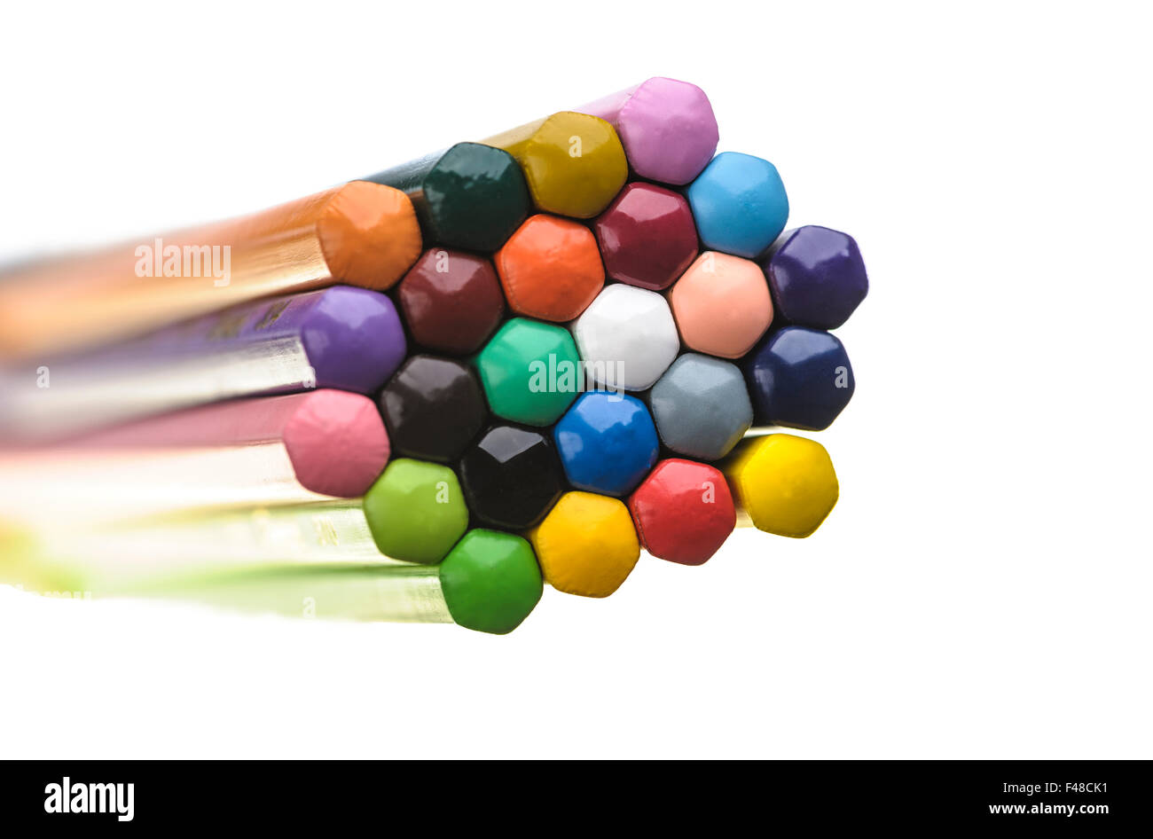 The ends of a group of coloured pencils arranged in a honeycomb pattern. Stock Photo