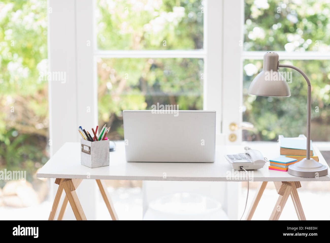 Laptop computer on desk with lamp Stock Photo