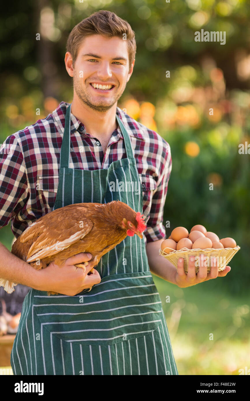 Happy farmer holding chicken and egg Stock Photo
