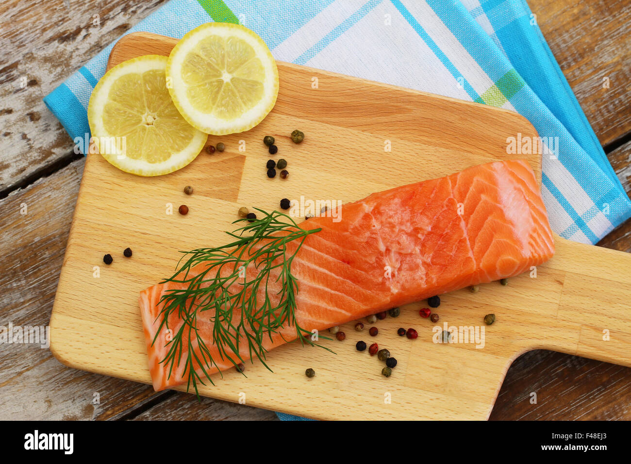 Uncooked salmon steak with lemon on wooden board Stock Photo