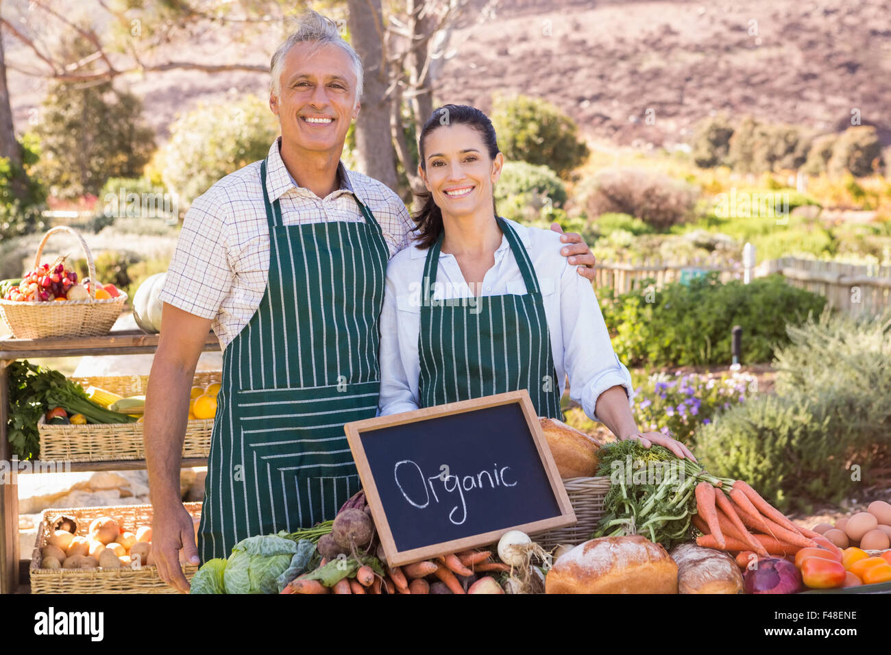 Couple selling organic vegetables at market Stock Photo - Alamy