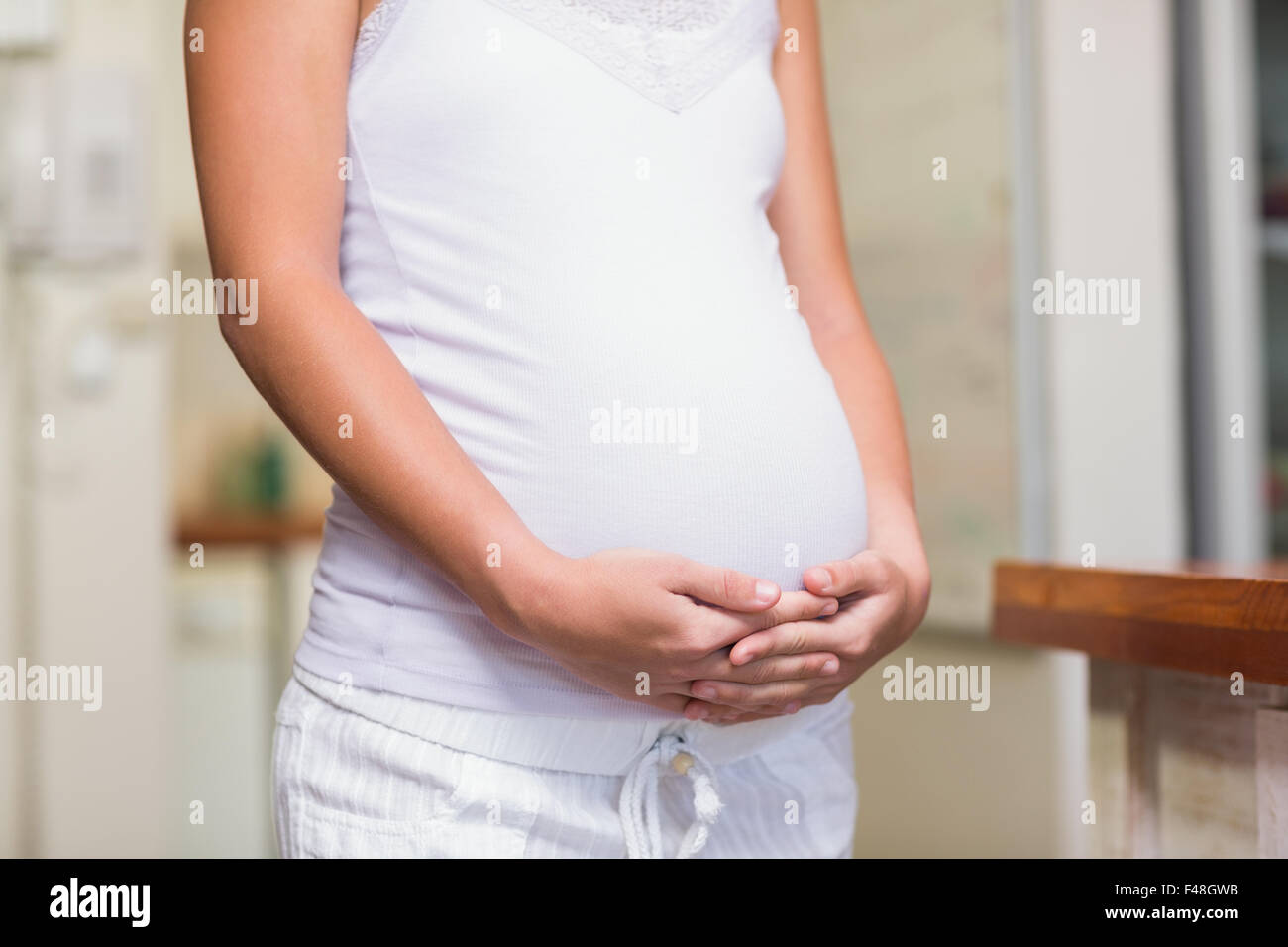 Pregnant woman cuddling her stomach Stock Photo Alamy