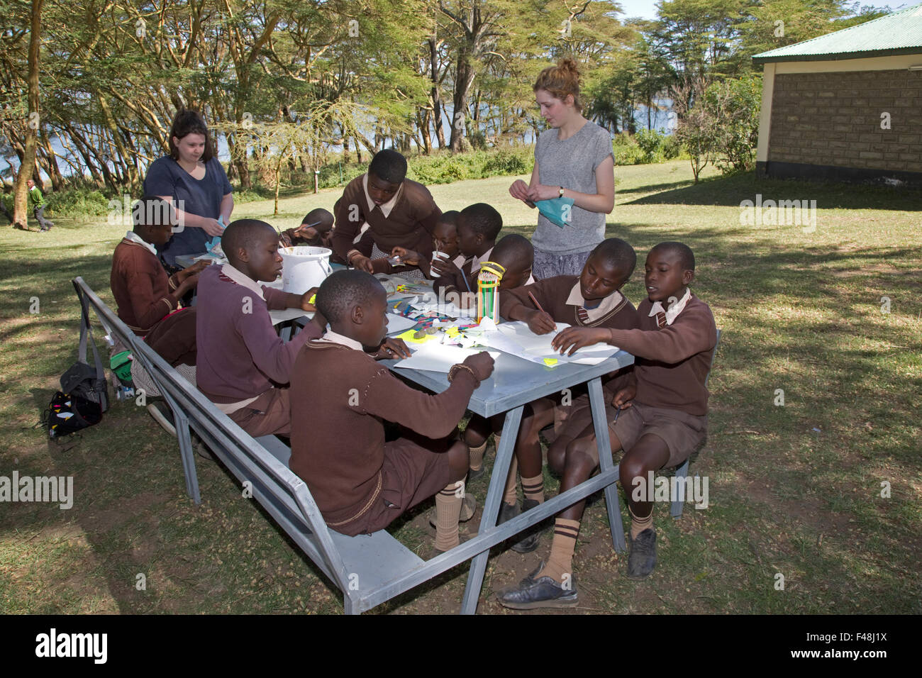 Charlotte & Lizzie working on art projects with Kenyan children Elsamere Open Day September 2015 Lake Naivasha Kenya Stock Photo