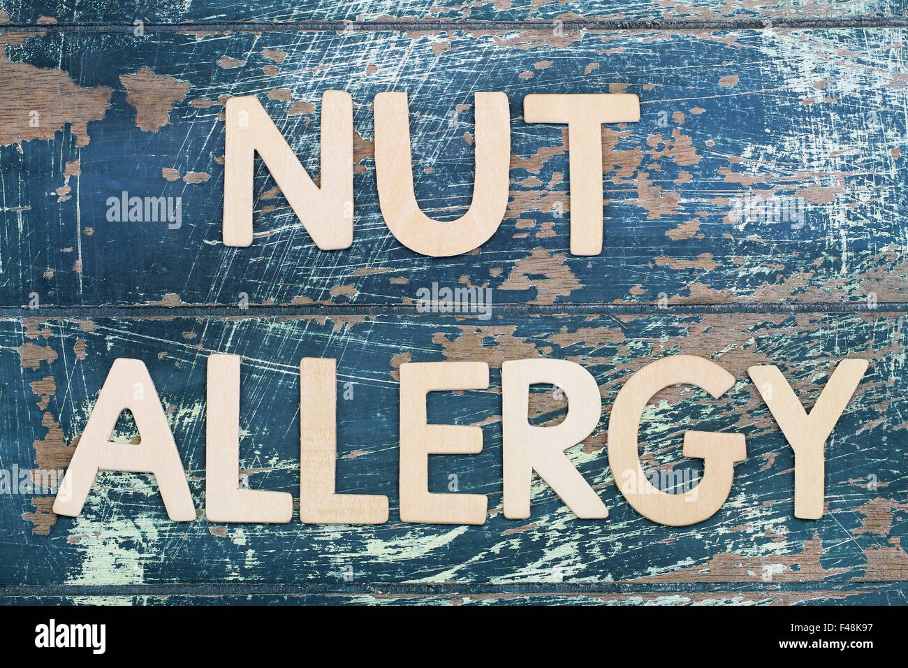 Nut allergy written on rustic wooden surface Stock Photo