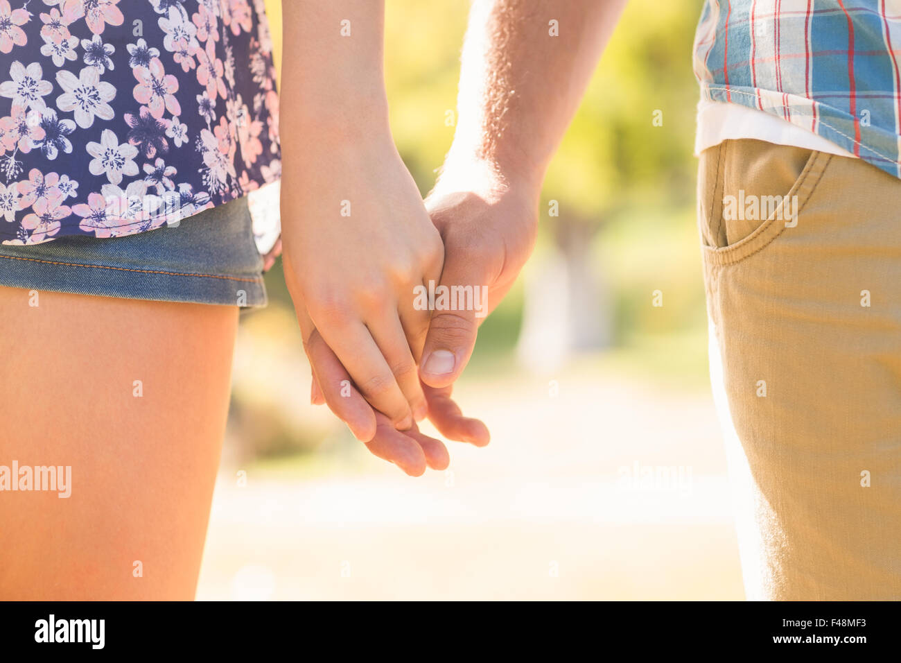 Cute couple holding hands in the park Stock Photo - Alamy
