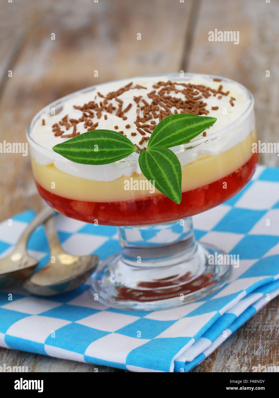 Strawberry trifle in dessert glass on checkered cloth on rustic wooden surface Stock Photo