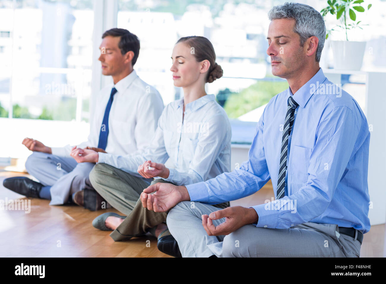 Business people doing yoga on floor Stock Photo - Alamy