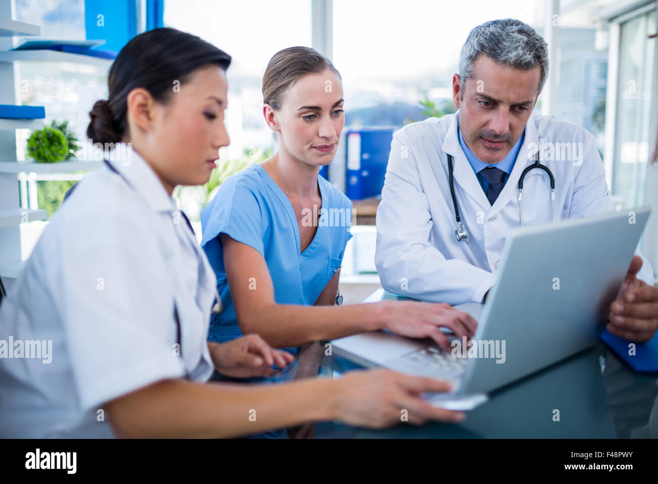 Doctors and nurse looking at laptop Stock Photo - Alamy