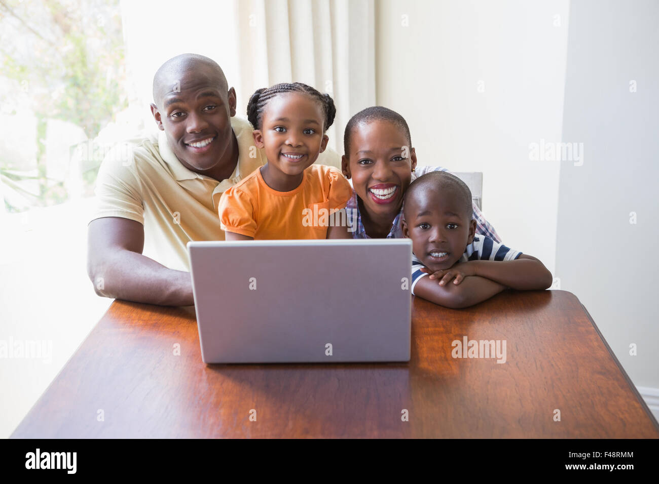 Happy smiling family using laptop Stock Photo - Alamy