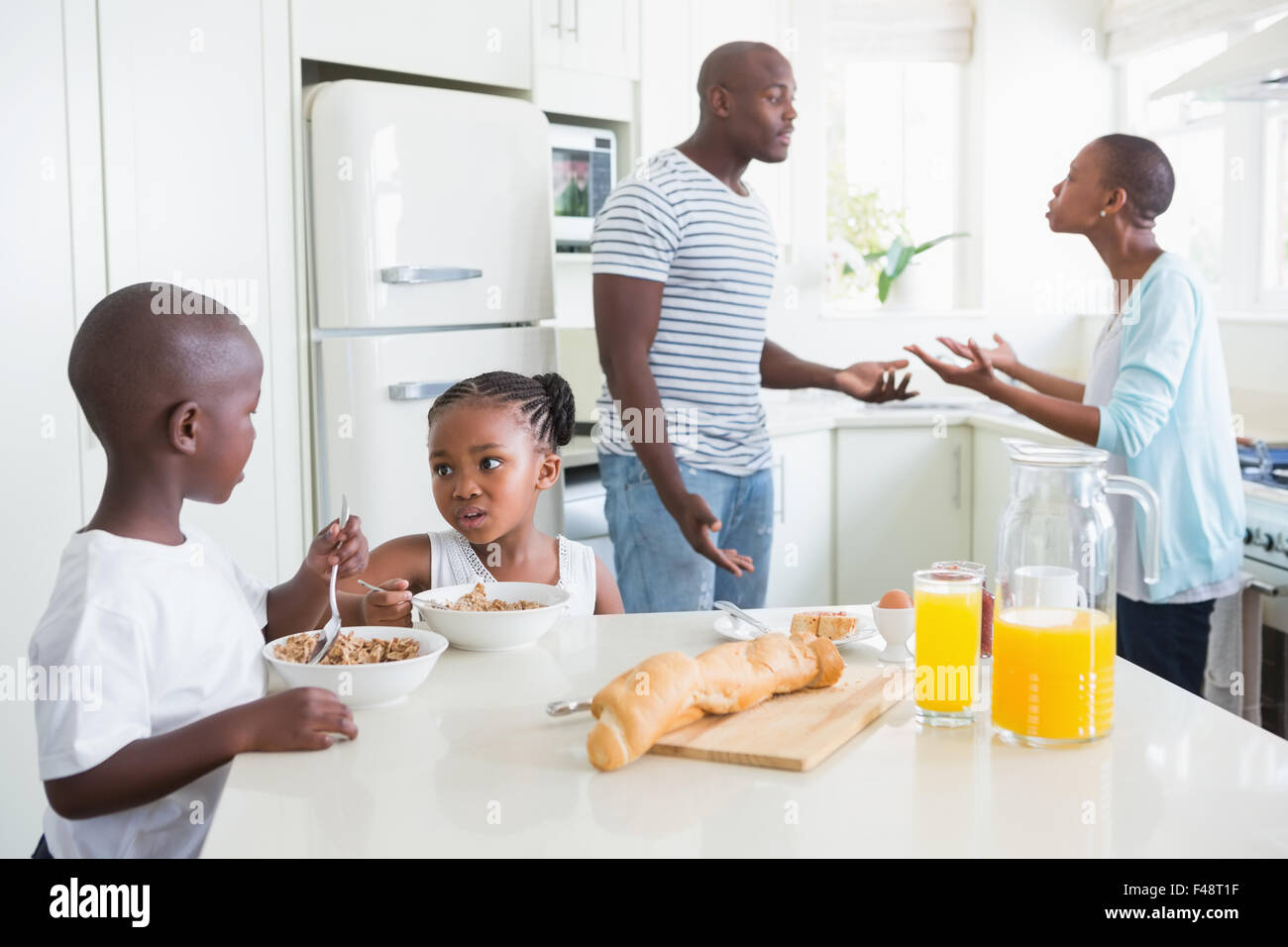 Happy family sitting and taking breakfast Stock Photo - Alamy