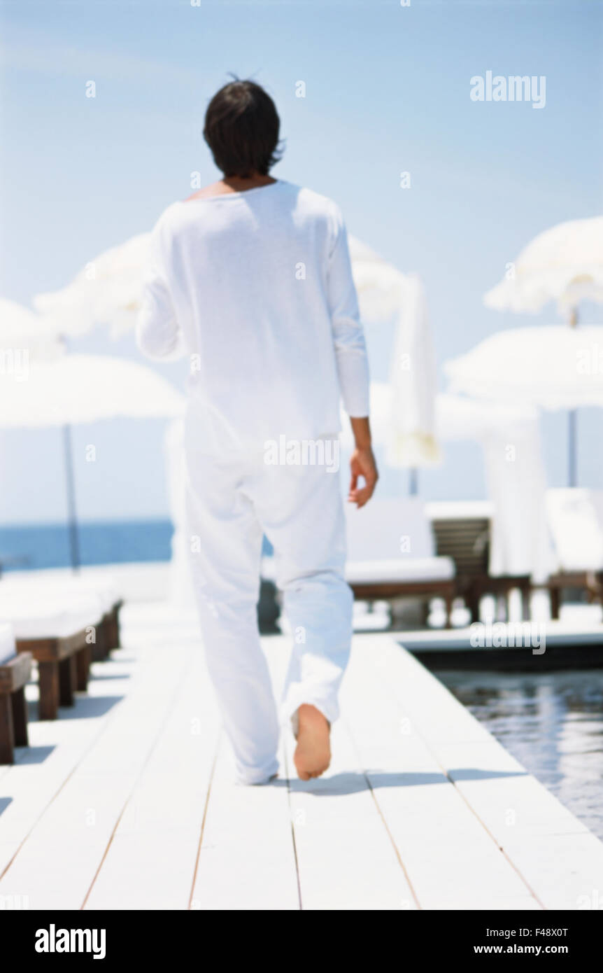Man dressed in white on a jetty. Stock Photo