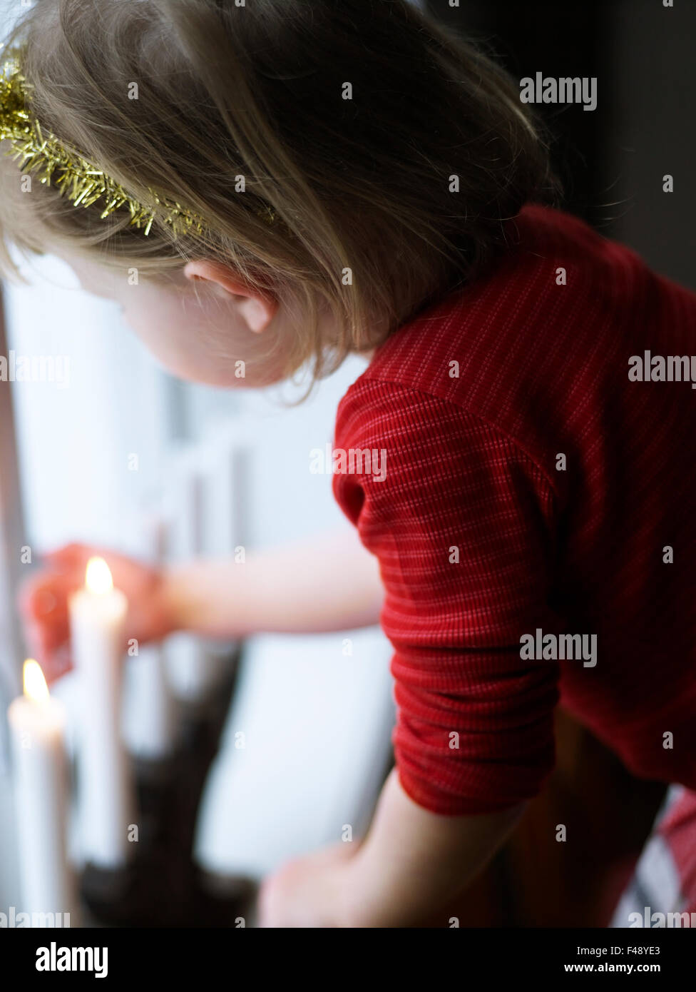 A girl with a advent candle in the window Stock Photo Alamy