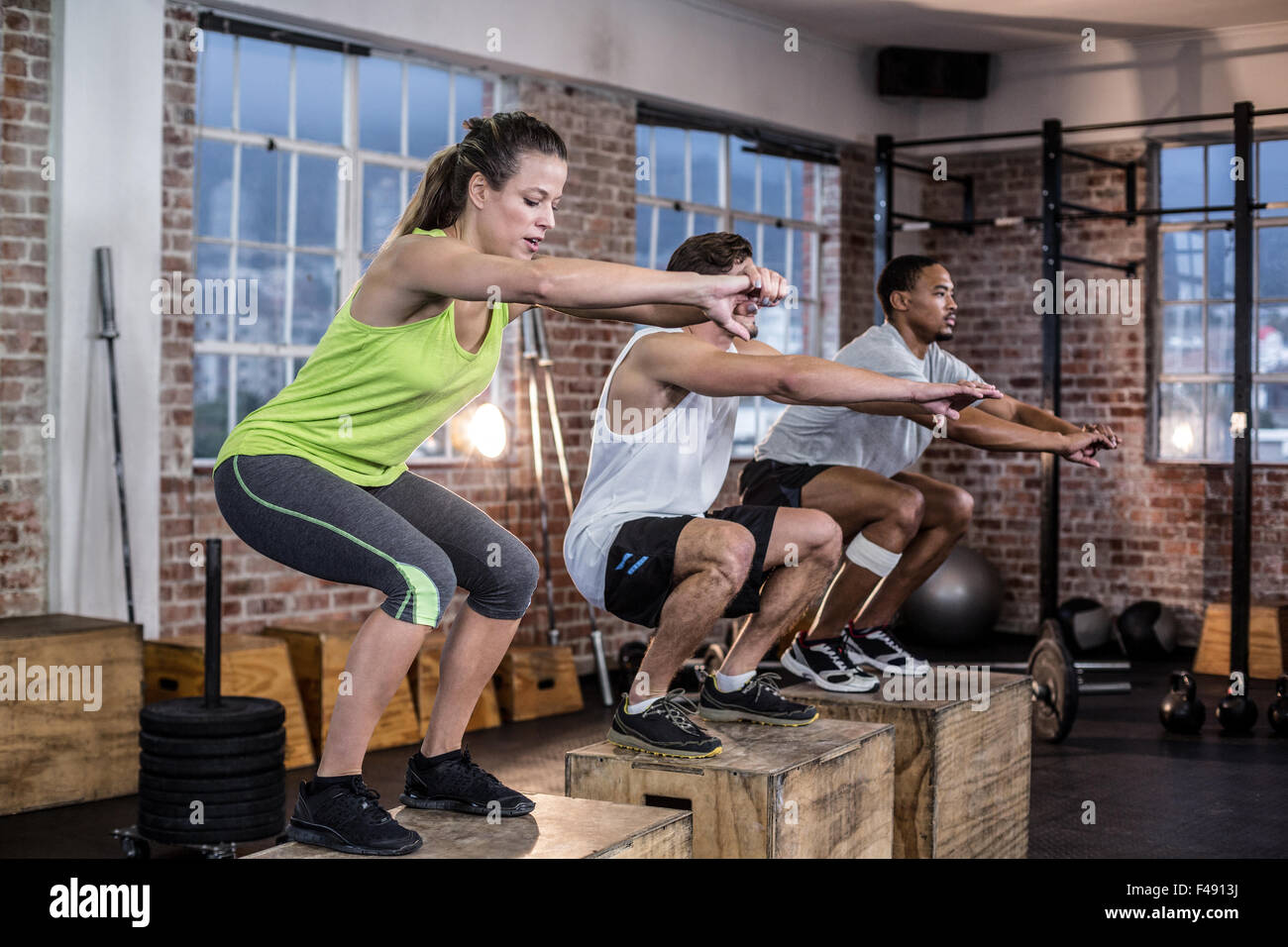 Three fit athletes squatting together Stock Photo Alamy