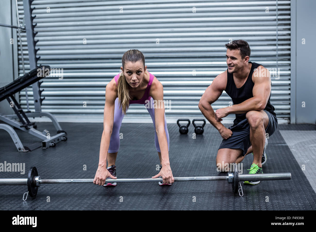 Attentive muscular woman lifting weight Stock Photo