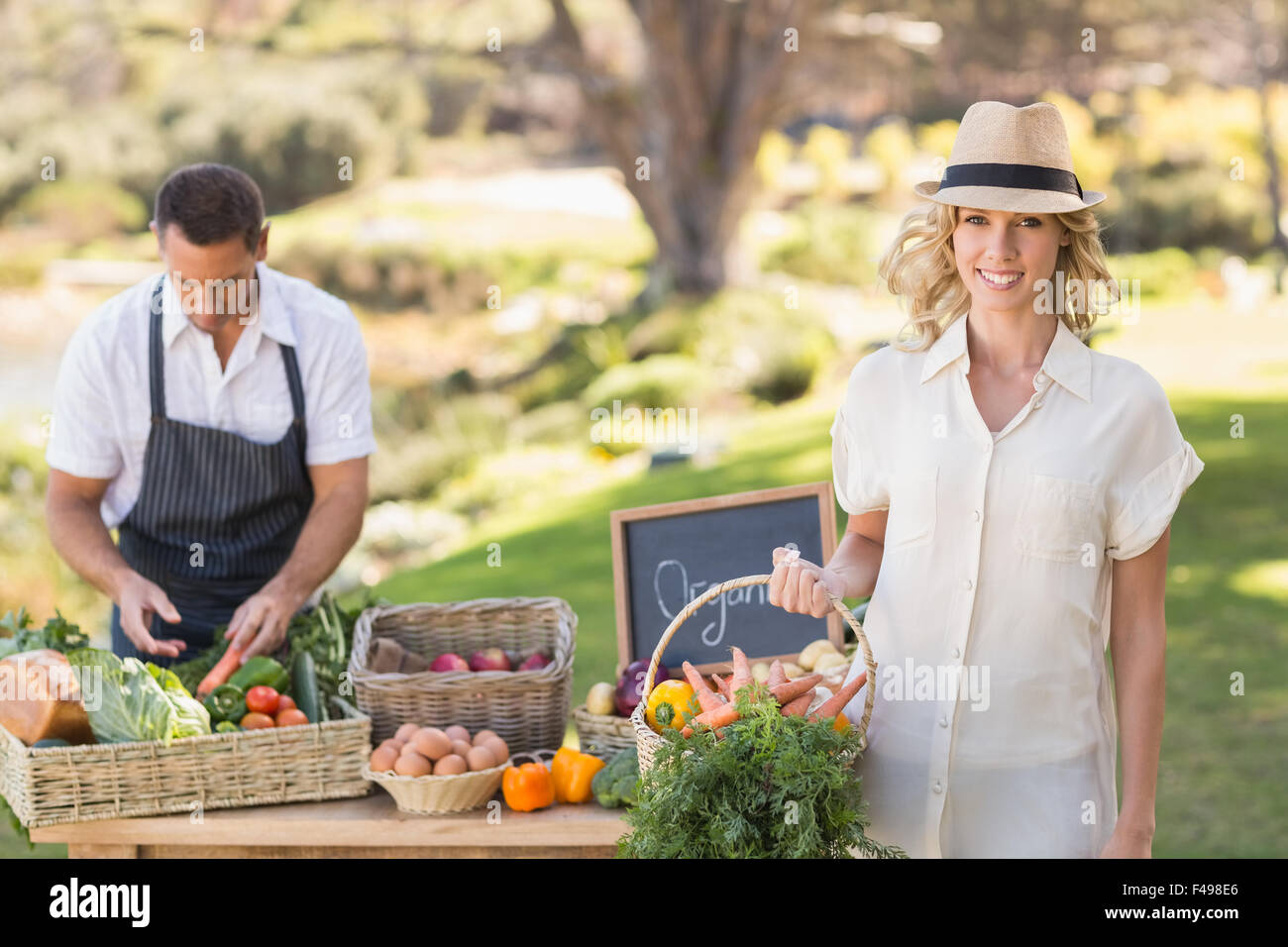 Blonde customer holding a vegetables basket Stock Photo - Alamy
