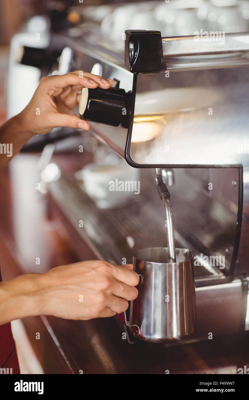 Barista steaming milk at the coffee machine Stock Photo Alamy