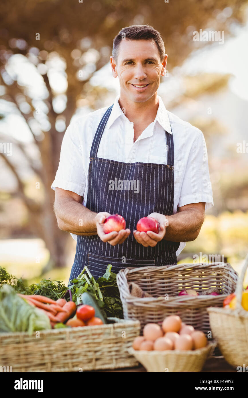 Smiling farmer holding two red apples Stock Photo - Alamy