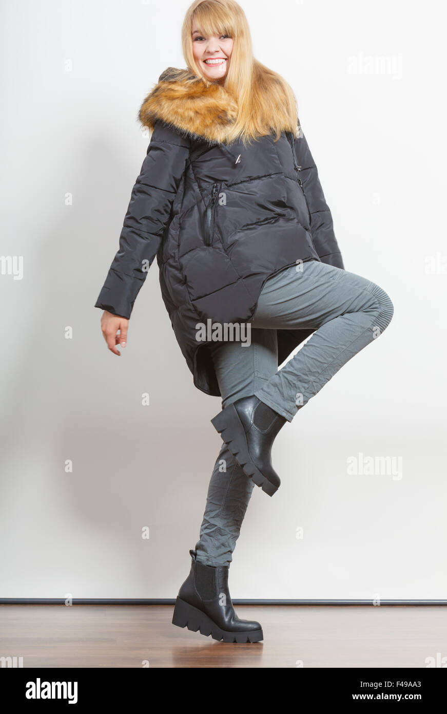 Beautiful smiling young fashionable girl wearing jacket with hood