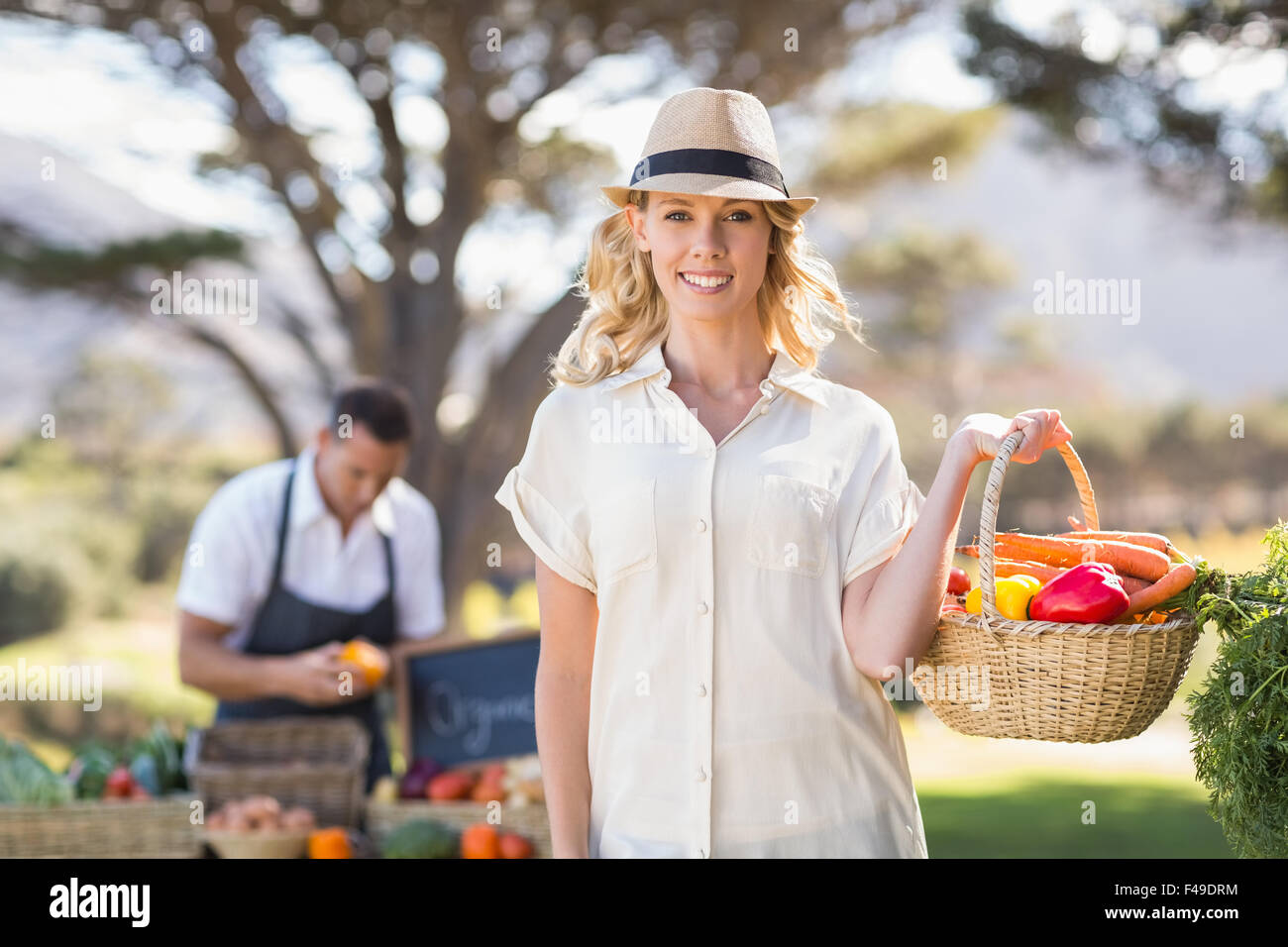 Blonde woman holding a vegetables basket Stock Photo - Alamy