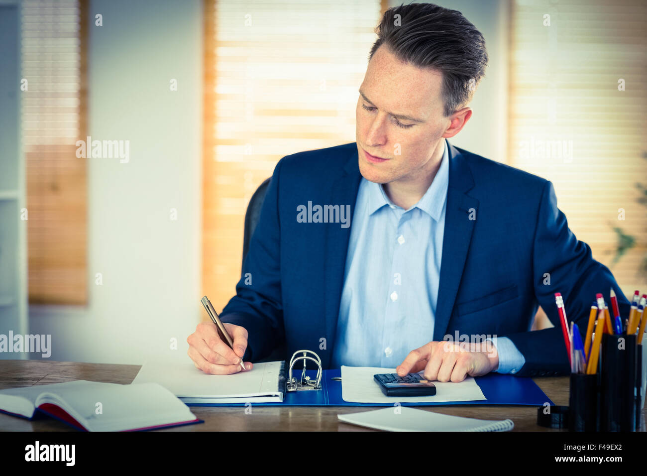 Concentrated businessman writing down Stock Photo Alamy