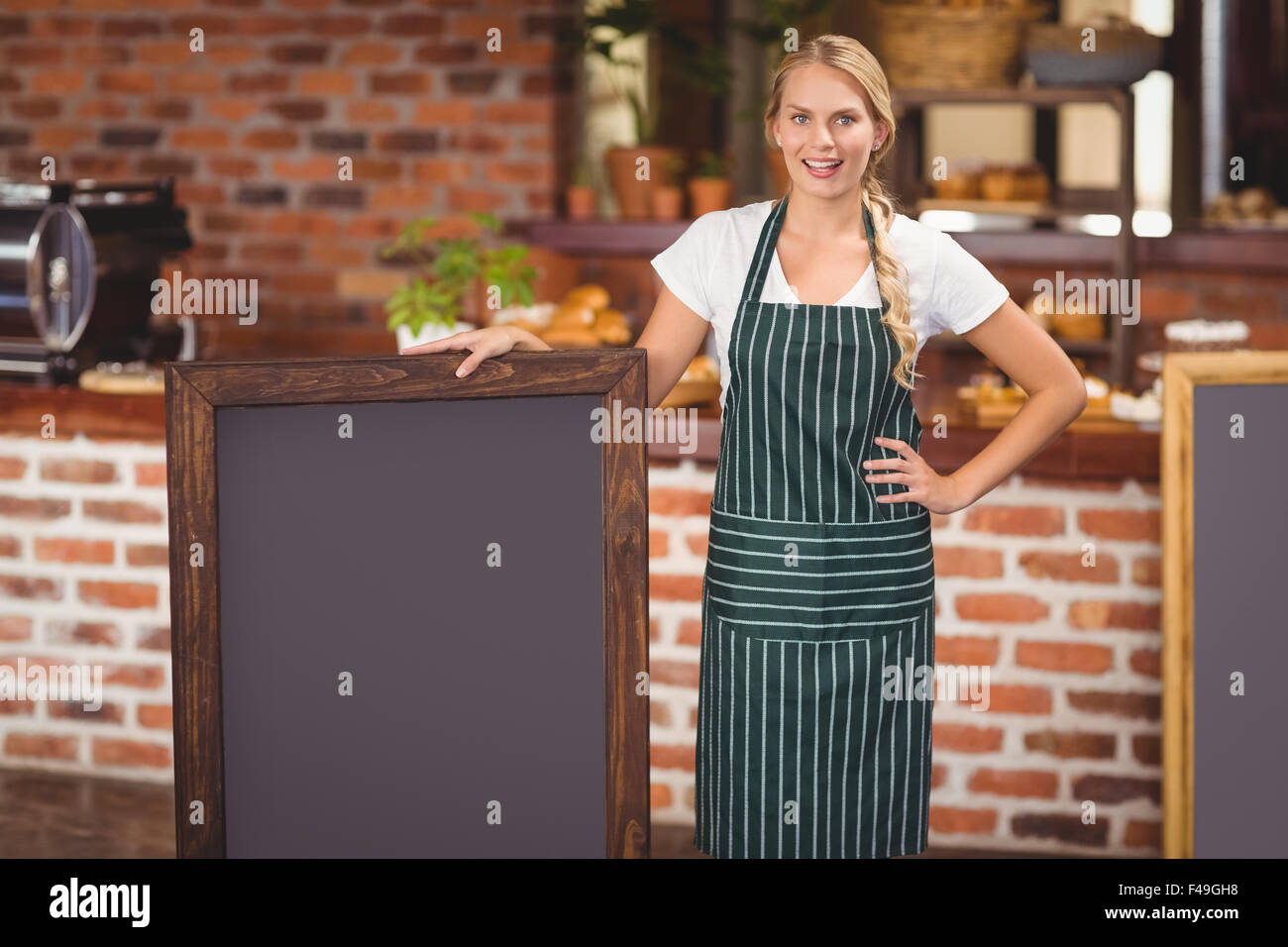 Pretty waitress holding a big chalkboard Stock Photo