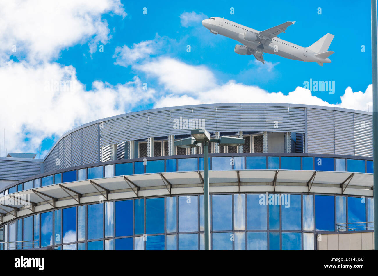 Aircraft flies over office building. Stock Photo