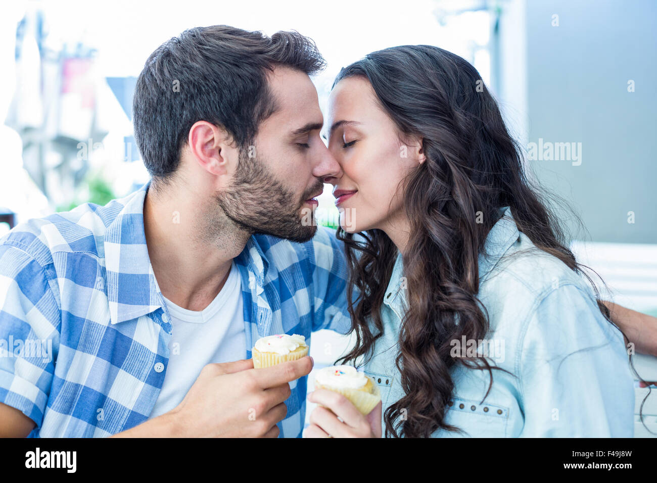 Couple kissing while holding cupcakes Stock Photo