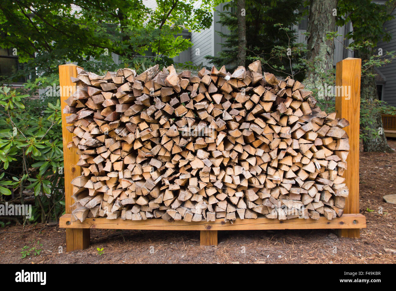 Rack of chopped logs for firewood in outdoor setting Stock Photo