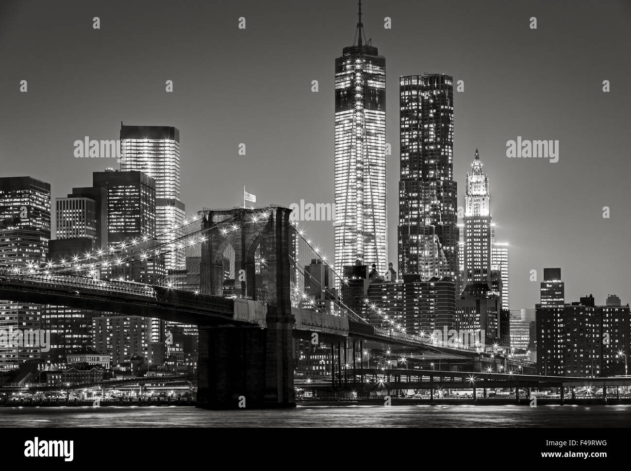 Black & White cityscape by night. View of Brooklyn Bridge, Lower Manhattan and Financial District's skyscrapers, New York City Stock Photo