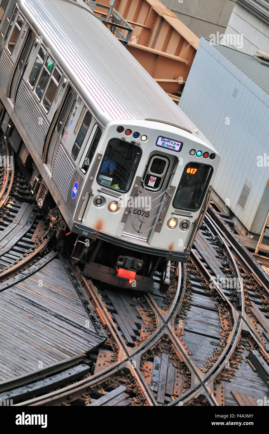 A CTA Green Line rapid transit train crosses a busy junction in Chicago ...