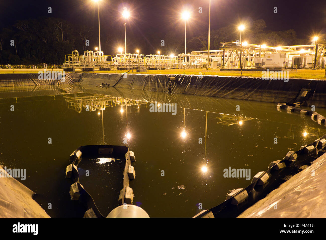 Reservoir of production water on an oil well platform  in the Ecuadorian Amazon, illuminated at night Stock Photo