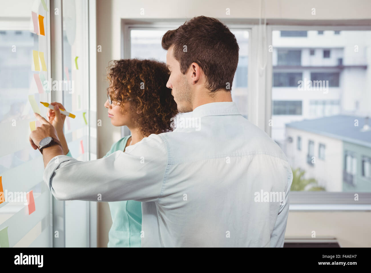 Business people writing and pointing on adhesive note Stock Photo