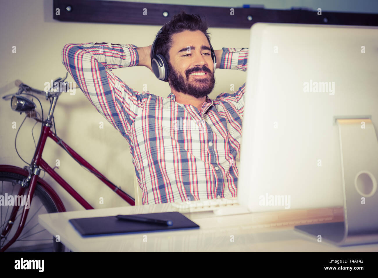 Happy businessman listening music while relaxing with arms raised Stock Photo