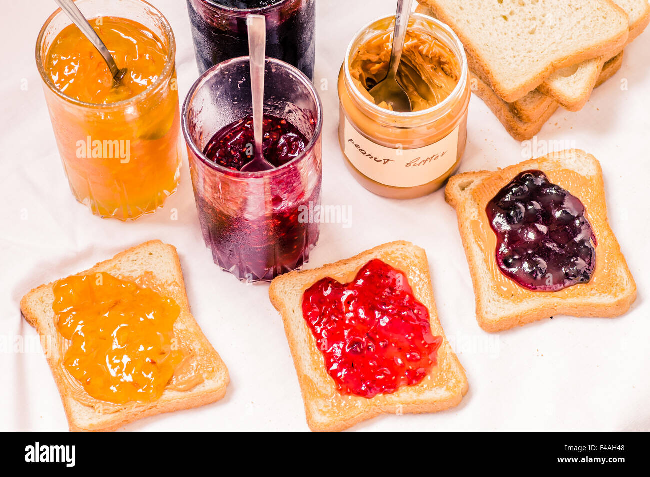 Toast sandwiches with peanut butter and jam raspberry, blueberries, orange top view Stock Photo