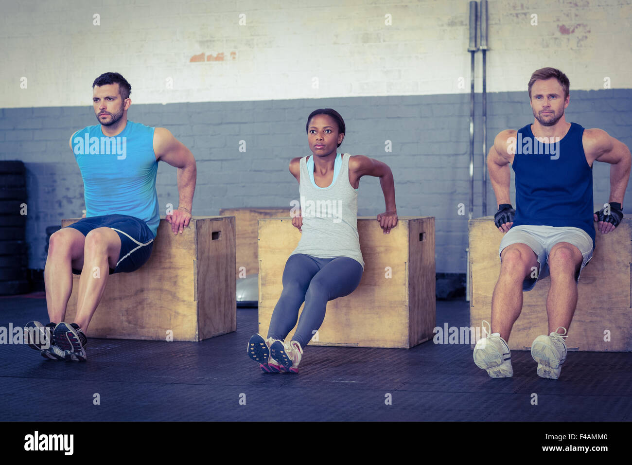 Three young bodybuilders doing exercises Stock Photo