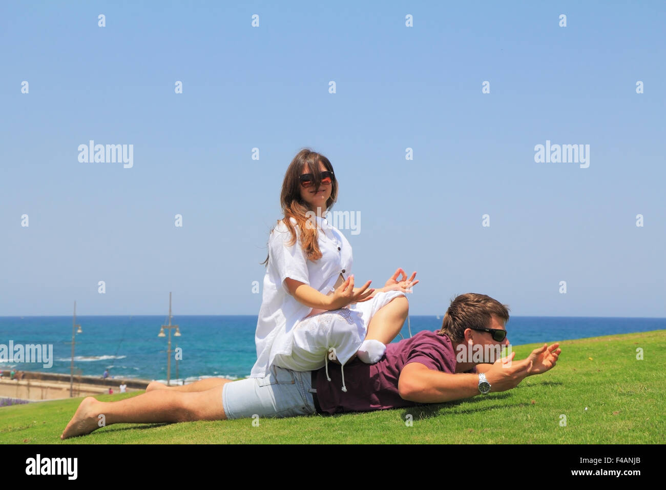 Young couple relaxing on the grass Stock Photo - Alamy