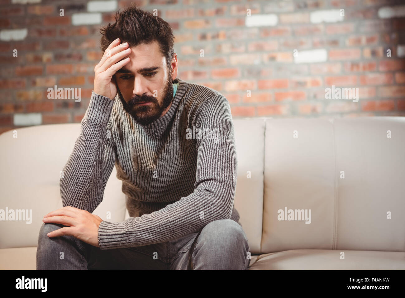 Depressed man with hand on forehead Stock Photo