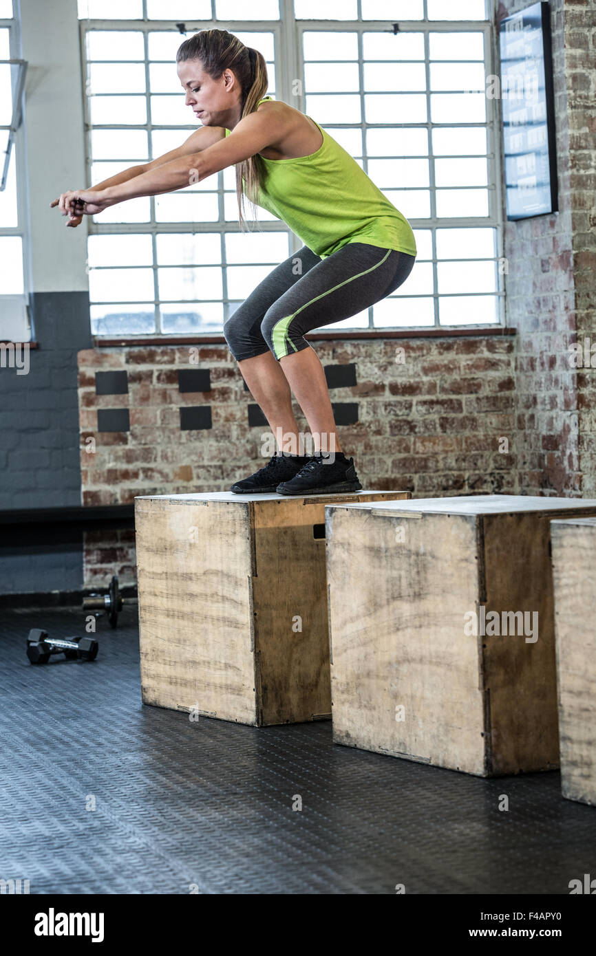 Fit woman doing a squat jump Stock Photo