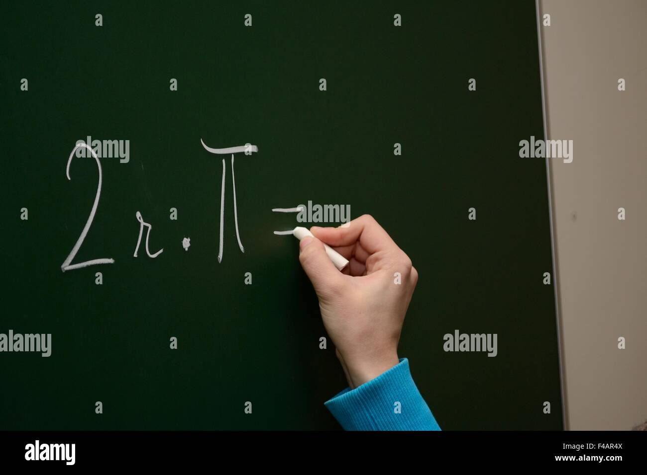 Student writes the formula on blackboard Stock Photo
