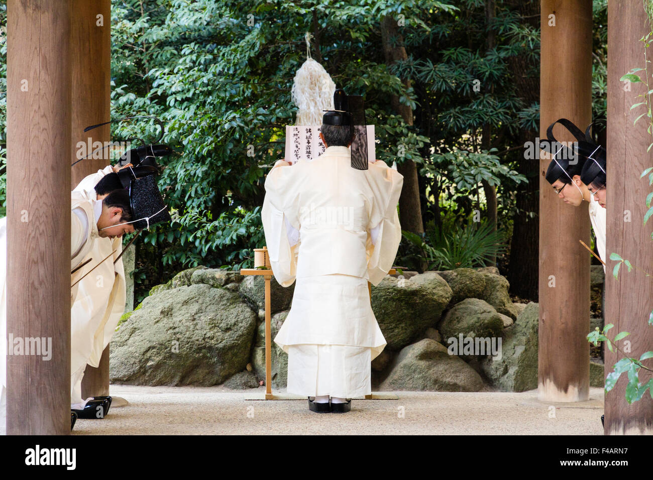 Nishinomiya shrine, Japan, Shinto Priests, Kannushi, with chief priest making offerings to four other priests. All wear Kammuri, black hats. Stock Photo