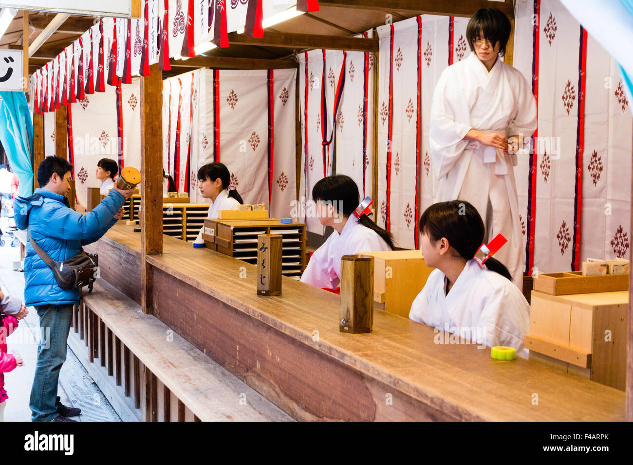 Japan, Nishinomiya shrine, New year Day, Shogatsu. Woman buying omikuji ...