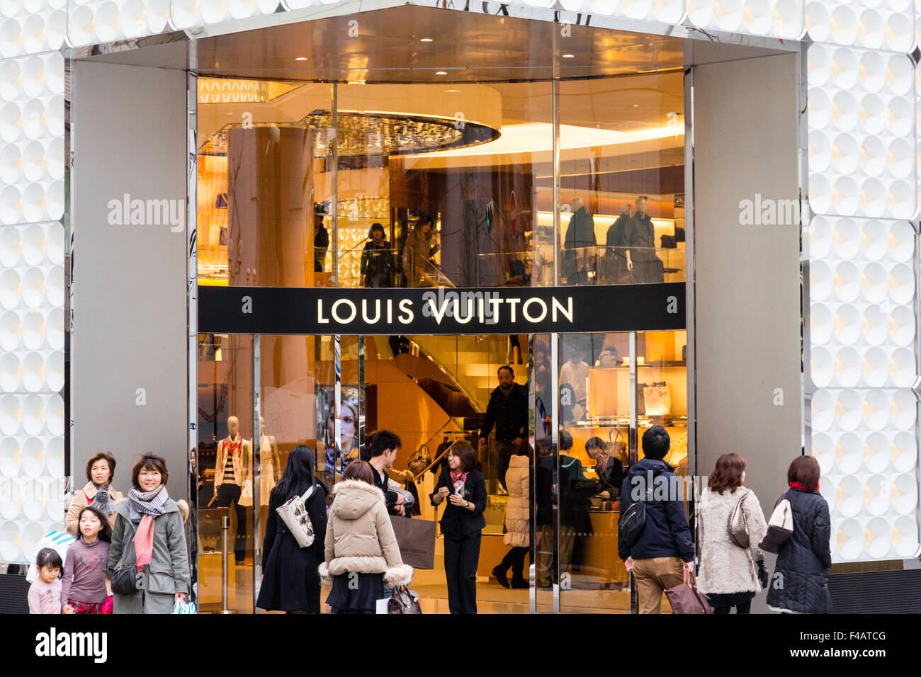 Japan. Louis Vuitton store building. Main entrance into illuminated  interior with shoppers outside entering, leaving and walking past. Golden  Hour Stock Photo - Alamy