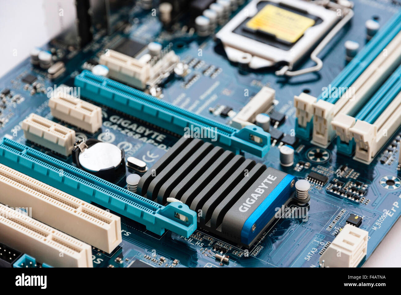 Computer motherboard showing PCI expansion slots, top of closed chip socket, Ram slots for memory and Gigabyte processor. Stock Photo
