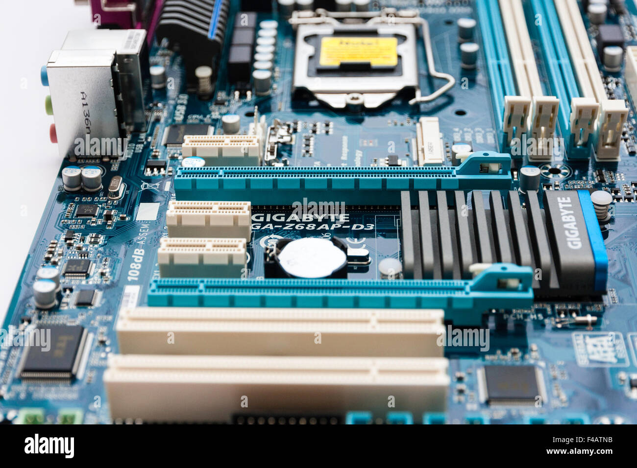 Computer motherboard showing PCI expansion slots, top of closed chip socket, Ram slots for memory and Gigabyte processor. Stock Photo