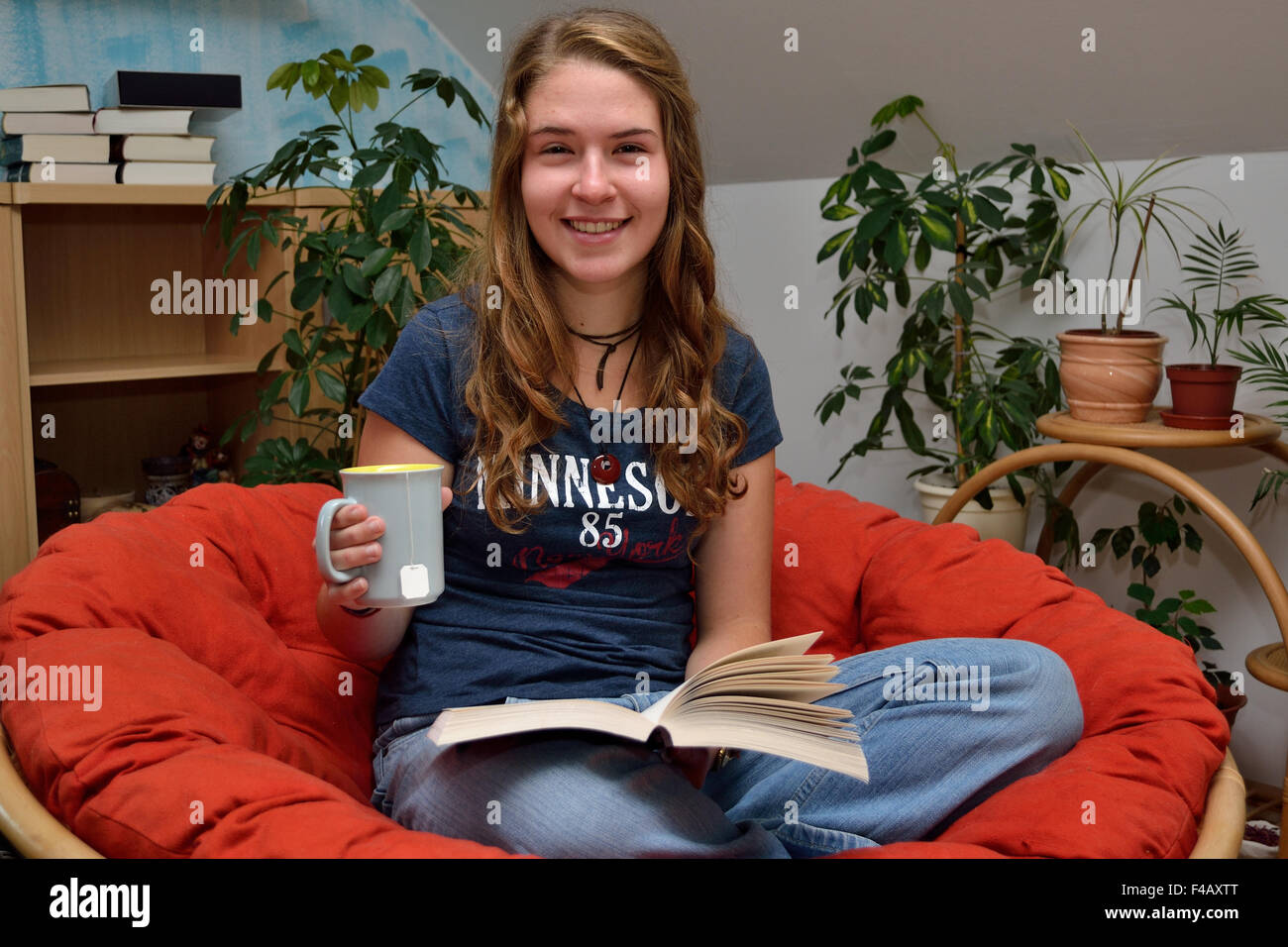 Teen reading and drinking tea Stock Photo