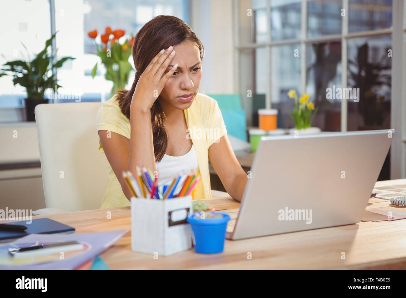 Creative businesswoman thinking while looking in laptop Stock Photo